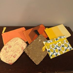 Six Ipsy bags in yellow and orange.